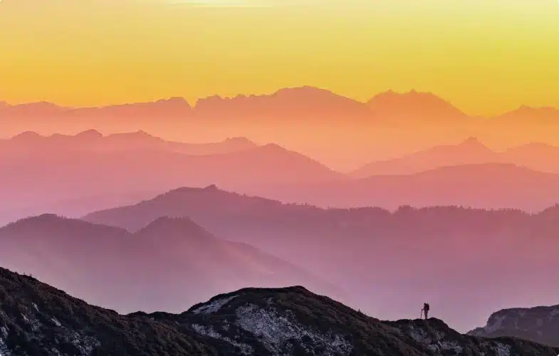 A hiker looking over a sunset